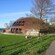 An oval building with a ridge down it's midline and recessed windows on the first and second floor.